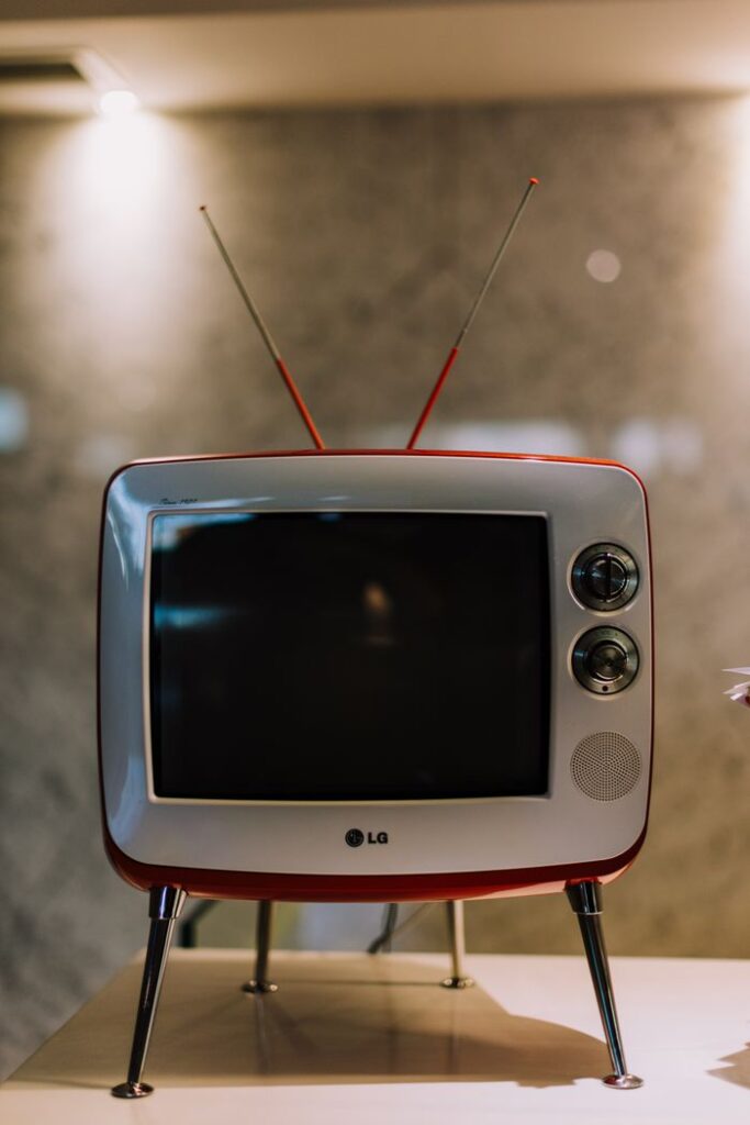 Close-up of a retro television with antennae on a table, capturing nostalgia.